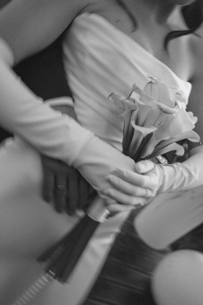 Bride's gloved hands holding a calla lily bouquet