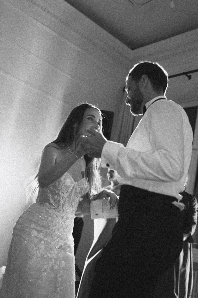 Bride and groom dancing and laughing in a bright hall