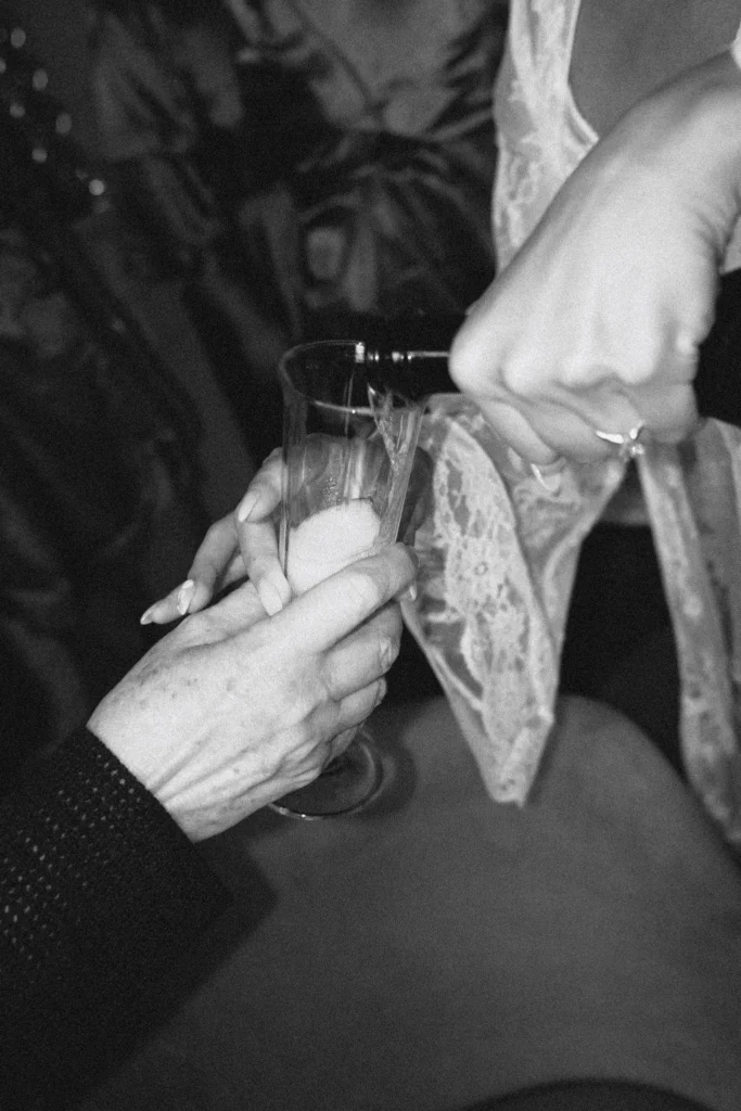 Dłonie gości z kieliszkami podczas toastu – detal
