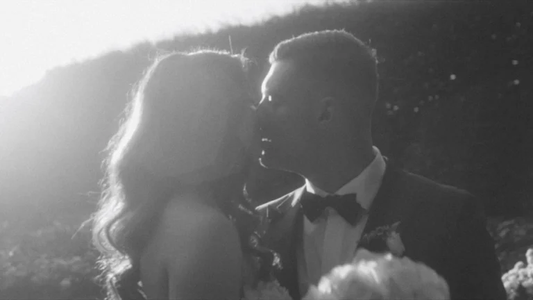 Backlit kiss on the cheek against a sunlit hedge