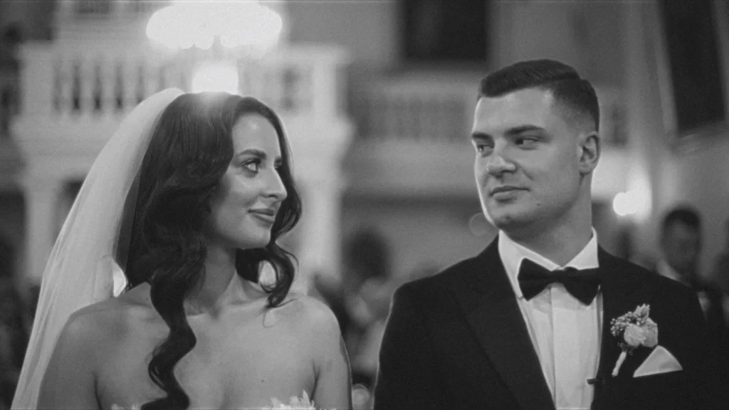 Bride and groom sharing a glance at the ceremony, palace balustrade behind