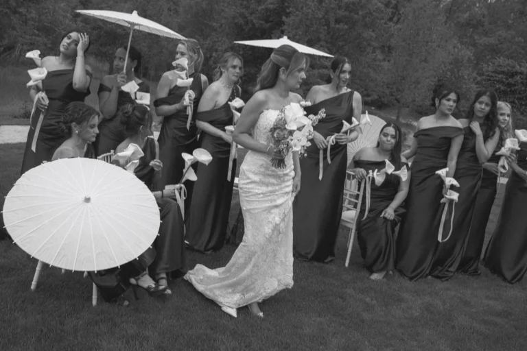 Bride among her bridesmaids with paper parasols and calla lilies