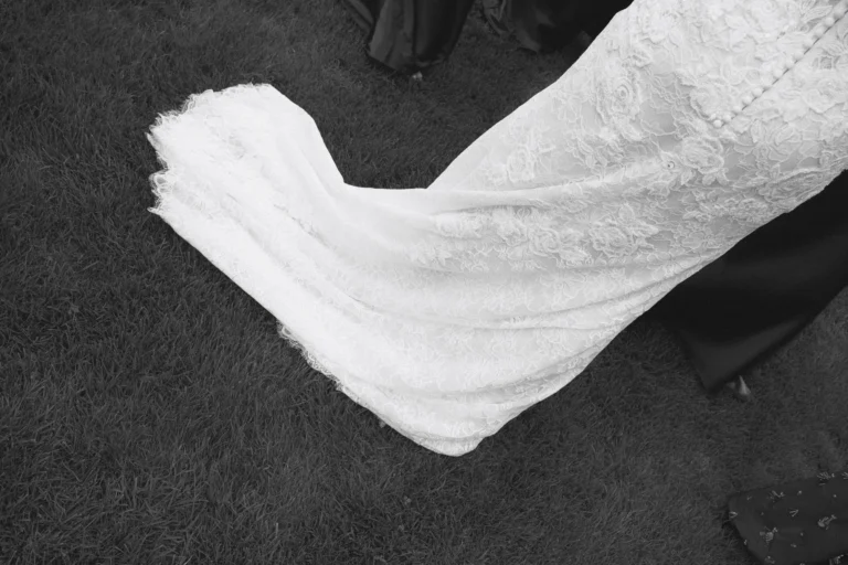 Lace wedding dress train spread across the grass
